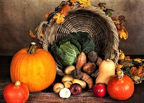 A basket with lots of vegetables sitting on a table